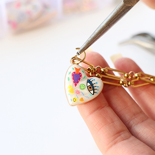 Create a funky charm necklace with metal charms with enamel